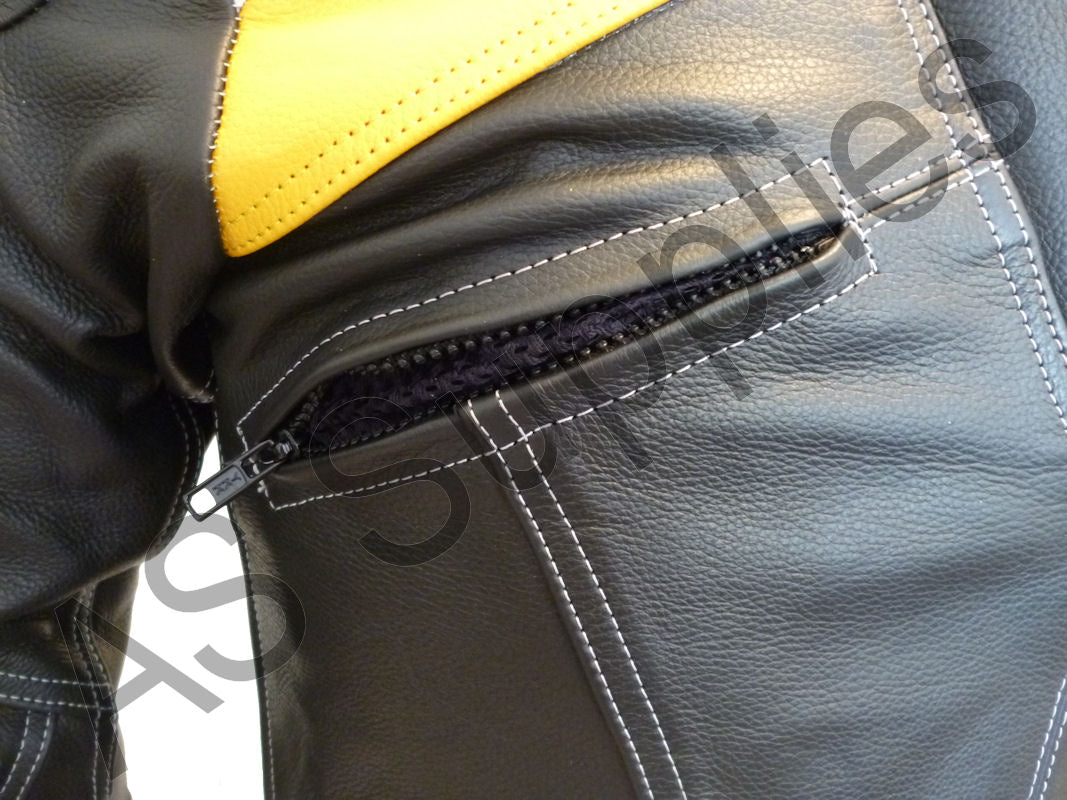 Close-up of a ventilation zip on a black and yellow leather jacket on a white background